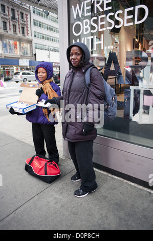 African-American mother and daughter sell chocolates on the corner of 42nd St. in Times Square, 2012. Stock Photo