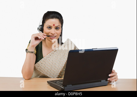 Female customer service representative working on a laptop Stock Photo