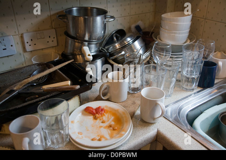A pile of dirty plates and washing up in the kitchen sink Stock Photo ...