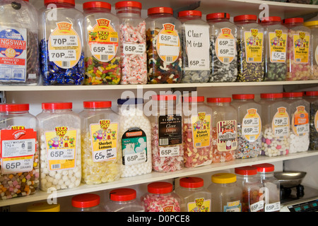 Jars of sweets on shelves in sweetshop Stock Photo