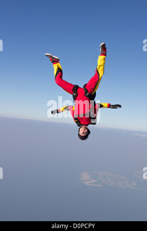 Skydiver girl is flying free over the Dubai earth and performance a head down move. The scenery is perfect from this hight. Stock Photo