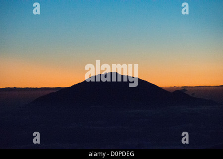 MOUNT KILIMANJARO, Tanzania — The summit of Mt Meru pokes through through the clouds just after sunset as seen from Arrow Glacier on Mt Kilimanjaro's Lemosho Route. Stock Photo