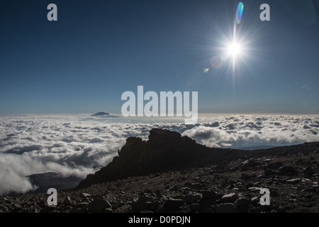 MOUNT KILIMANJARO, Tanzania — The summit of Mt Meru pokes through through the clouds as seen from Arrow Glacier on Mt Kilimanjaro's Lemosho Route. Stock Photo