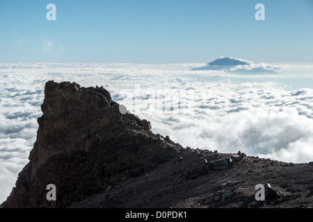 MOUNT KILIMANJARO, Tanzania — The summit of Mt Meru pokes through the clouds as seen from Arrow Glacier on Mt Kilimanjaro's Lemosho Route. Stock Photo