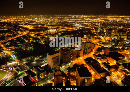 NEWARK, New Jersey, United States — An aerial view of downtown Newark at night, captured from a helicopter at approximately 500 feet altitude, showcases the city's vibrant urban landscape. The bright lights of streets, buildings, and landmarks create a dazzling tapestry against the dark backdrop, offering a striking perspective of New Jersey's largest city. Note: Some high ISO noise is visible at full resolution due to the challenging low-light conditions of night aerial photography. Stock Photo