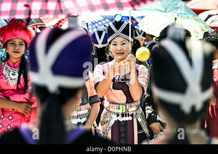 Hmong New Year Ball Game Traditional Costumes Silver Coins Phonsavan Laos // PHONSAVAN, Laos — Young Hmong women toss a ball during the annual New Year festival in Xieng Khouang Province. This courtship game, known as *pov pob*, historically allowed youth from dispersed farming villages to meet potential spouses after the autumn harvest. The heavy belts of silver coins worn by the participants serve as a public display of family wealth to prospective suitors. Stock Photo