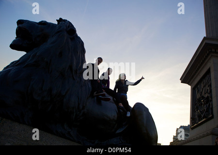 Posing on Lion Statue, Trafalgar Square London, UK Stock Photo