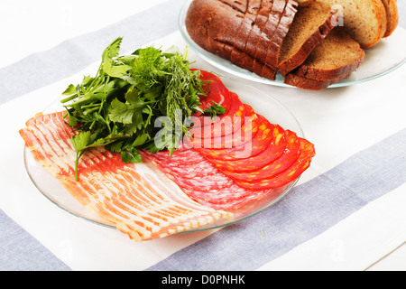 Sliced meat and greens on plate Stock Photo