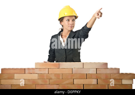 Young female builder near brick wall Stock Photo