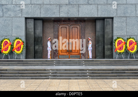 HANOI, Vietnam — Two guards in full dress uniform stand guard at the entrance to the Ho Chin Minh Mausoleum. A large memorial in downtown Hanoi surrounded by Ba Dinh Square, the Ho Chi Minh Mausoleum houses the embalmed body of former Vietnamese leader and founding president Ho Chi Minh. Stock Photo