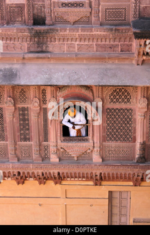 man looking out through Intricate decorative carved window of Mehrangarh fort  Jodhpur, Rajasthan, Stock Photo