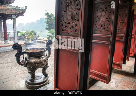 HANOI, Vietnam — Doors and incense urn at the Temple of the Jade Mountain (Ngoc Son Temple) on Hoan Kiem Lake in the heart of Hanoi's Old Quarter. The temple was established on the small Jade Island near the northern shore of the lake in the 18th century and is in honor of the 13-century military leader Tran Hung Dao. Stock Photo