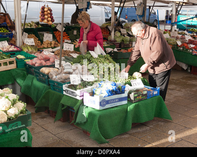 Man and woman serving themselves with vegetables at the twice weekly Market Day in Northallerton North Yorkshire UK Stock Photo