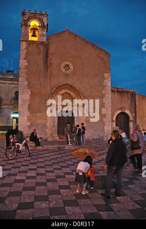 Children play by a church in Taormina  piazza -Sicily at sunset. Stock Photo