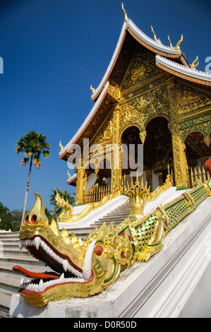 LUANG PRABANG, Laos — Golden naga (King Cobras) adorn the stairs of Haw Pha Bang (Palace Chapel) at the Royal Palace Museum in Luang Prabang, Laos. The ornate chapel, located in the northeastern corner of the museum grounds, showcases traditional Lao architecture and Buddhist symbolism. Stock Photo