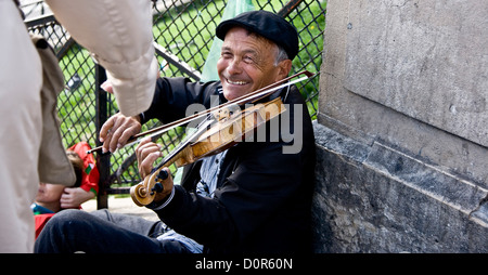 Smiling elderly violin busker accepting money Sacre Coeur Paris France Europe Stock Photo