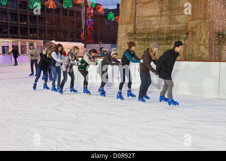 Glasgow, Scotland, UK. Young people skating in a conga line in George Square, central Glasgow where an ice-rink was opened on 24th November 2012 and will continue until 6th January 2012. Photo taken on 29th November 2012. Stock Photo