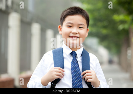 Portrait of cute schoolboy in uniform on the way to school Stock Photo