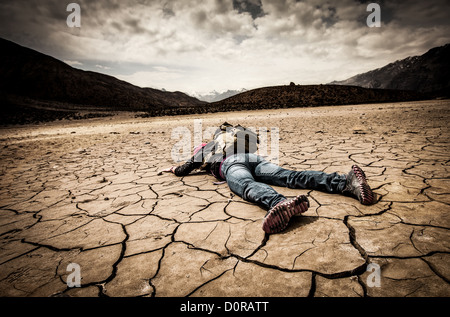 person lays on the dried ground Stock Photo