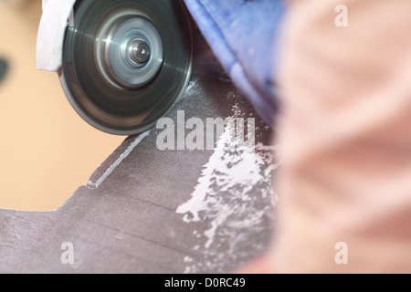 grinder worker cuts a stone the electric tool worker is tiling at home, tile Stock Photo