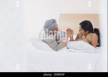 Couple arm wrestling on the bed Stock Photo