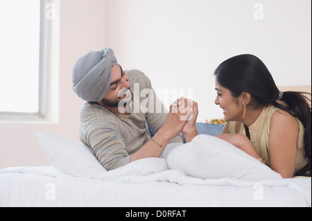 Couple arm wrestling on the bed Stock Photo
