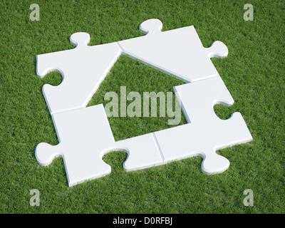Puzzle house symbol on grass Stock Photo