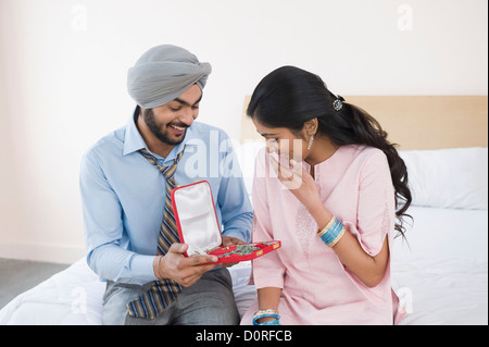 Man giving a necklace to a woman Stock Photo