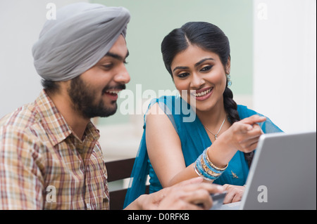 Couple using a laptop and smiling Stock Photo
