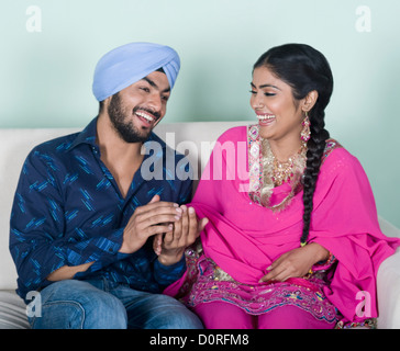 Couple sitting on a couch and smiling Stock Photo