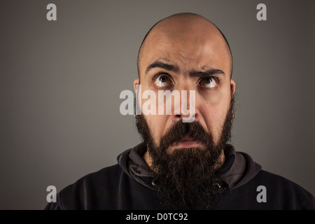 Bearded man doubtfully thinking Stock Photo