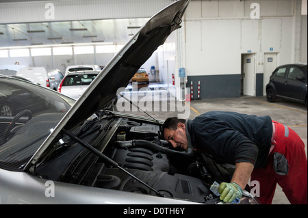 Car mechanic checking motor in auto garage Stock Photo