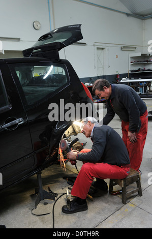 Two mechanics working in auto garage Stock Photo