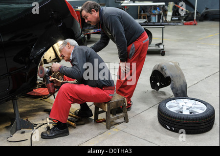 Two mechanics working in auto garage Stock Photo