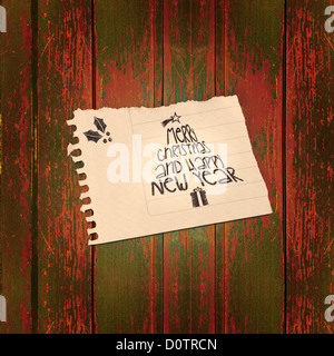 Vintage Merry Christmas and happy new year paper note over wooden background. Included clipping path, so you can easily cut it out and place over the top of a design. Stock Photo