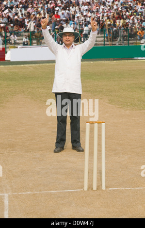 Cricket umpire signaling Six runs Stock Photo