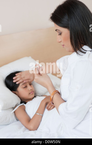 Woman checking fever of her daughter Stock Photo
