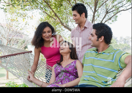 Friends enjoying in a hammock in a garden Stock Photo