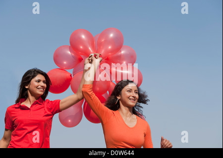 Friends holding balloons and enjoying Stock Photo