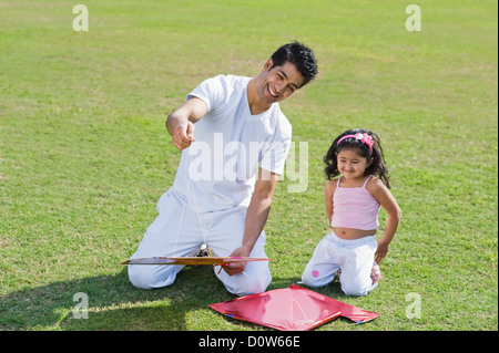 Man holding a kite with his daughter, Gurgaon, Haryana, India Stock Photo