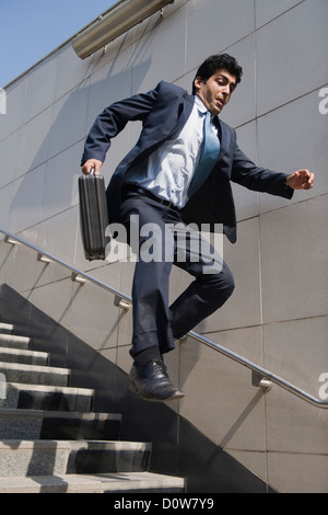Businessman rushing down stairs of a subway, Gurgaon, Haryana, India Stock Photo