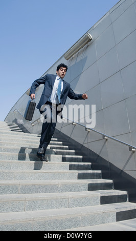 Businessman rushing down stairs of a subway, Gurgaon, Haryana, India Stock Photo