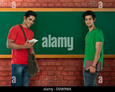 Portrait of two university students smiling in a classroom Stock Photo