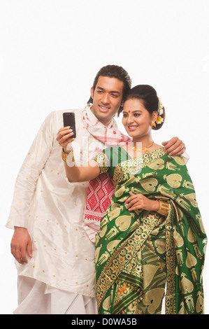 Couple in traditional clothing taking a picture of themselves Stock Photo