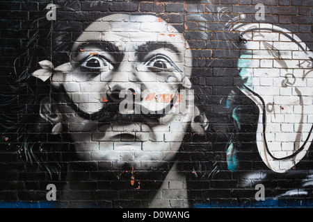 Salvador Dali like graffiti portrait painting on a brick wall. Stock Photo