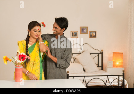 Man putting flower in his wife's hair Stock Photo