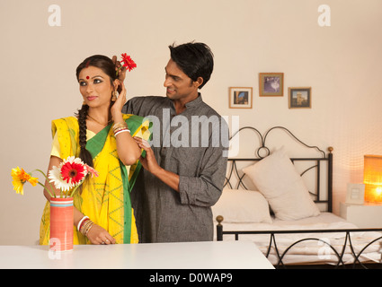 Man putting flower in his wife's hair Stock Photo