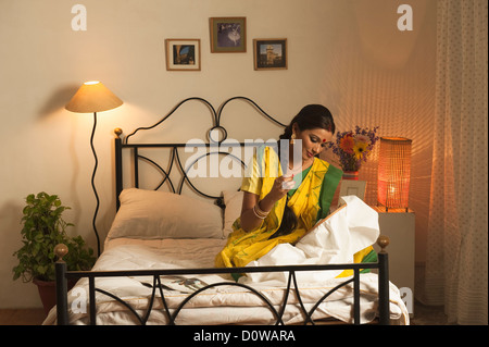 Bengali woman doing embroidery work in the bedroom Stock Photo