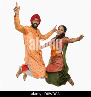 Sikh couple doing Bhangra the folk dance of Punjab in India Stock Photo