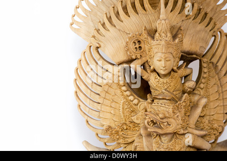 Hand carved Vishnu, Garuda, Nagas wooden statue from Bali on white background Stock Photo